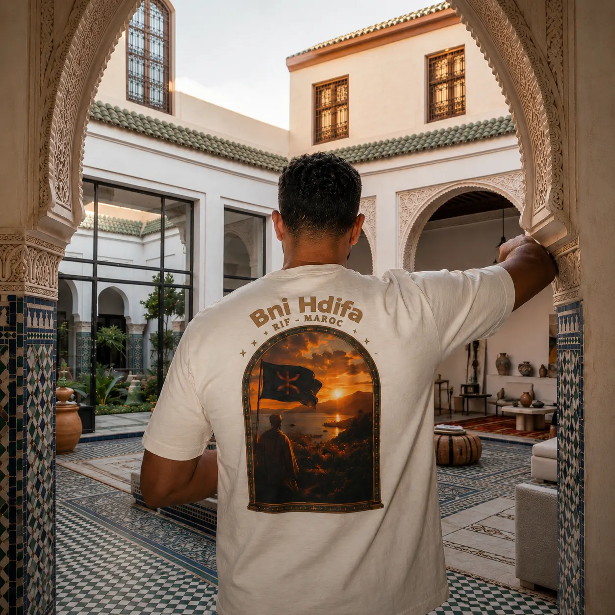 Man in een Marokkaanse riad, gezien van achter, dragend een RMRSE shirt met eigen plaatsnaam-print
